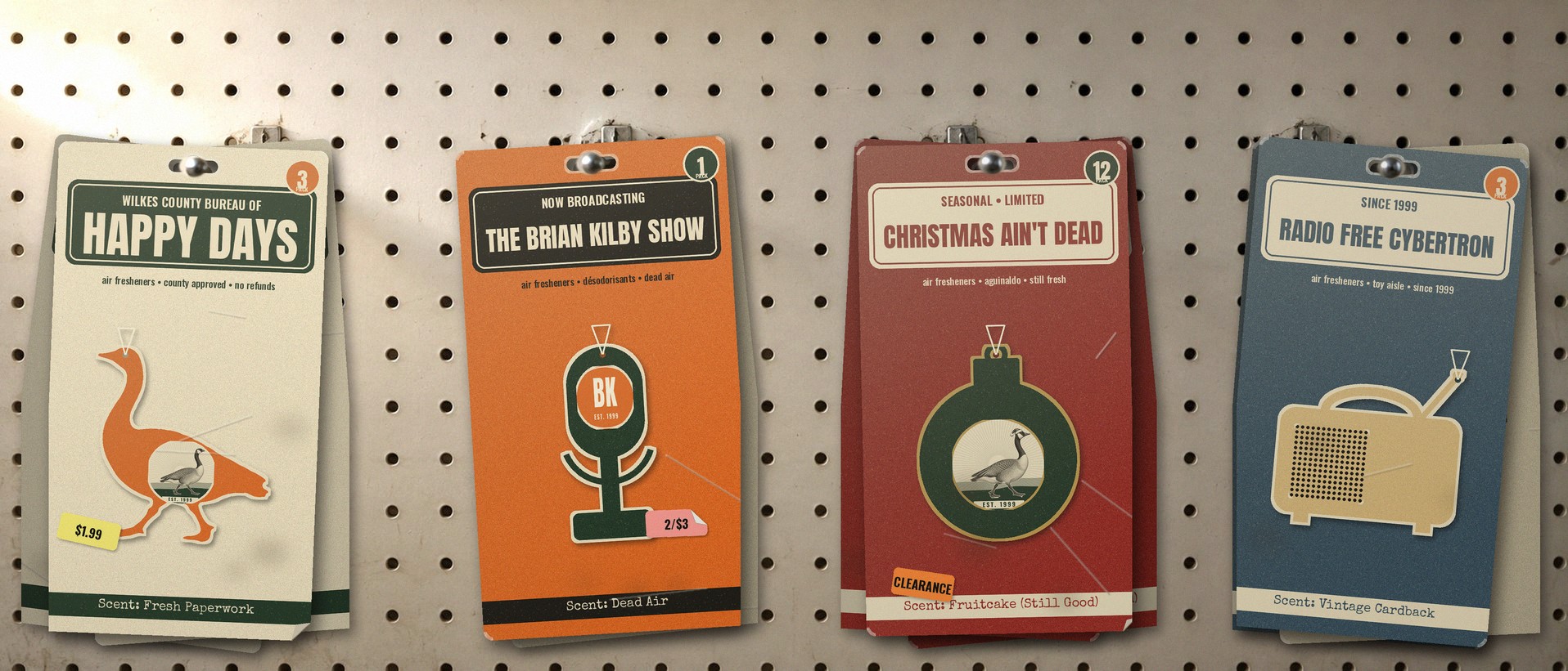 Shelf-worn air freshener packs hanging on a store pegboard: Wilkes County Bureau of Happy Days, The Brian Kilby Show, Christmas Ain't Dead and Radio Free Cybertron